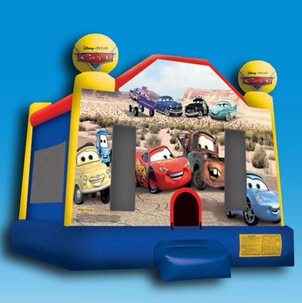 Colorful bounce house with Cars theme, featuring animated car characters on the front, set up on a grassy area.