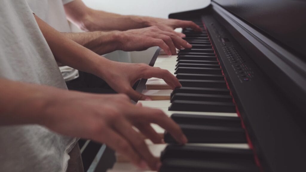 Teenage girl and her dad play a grand piano together, sharing a touching musical moment in a cozy room.